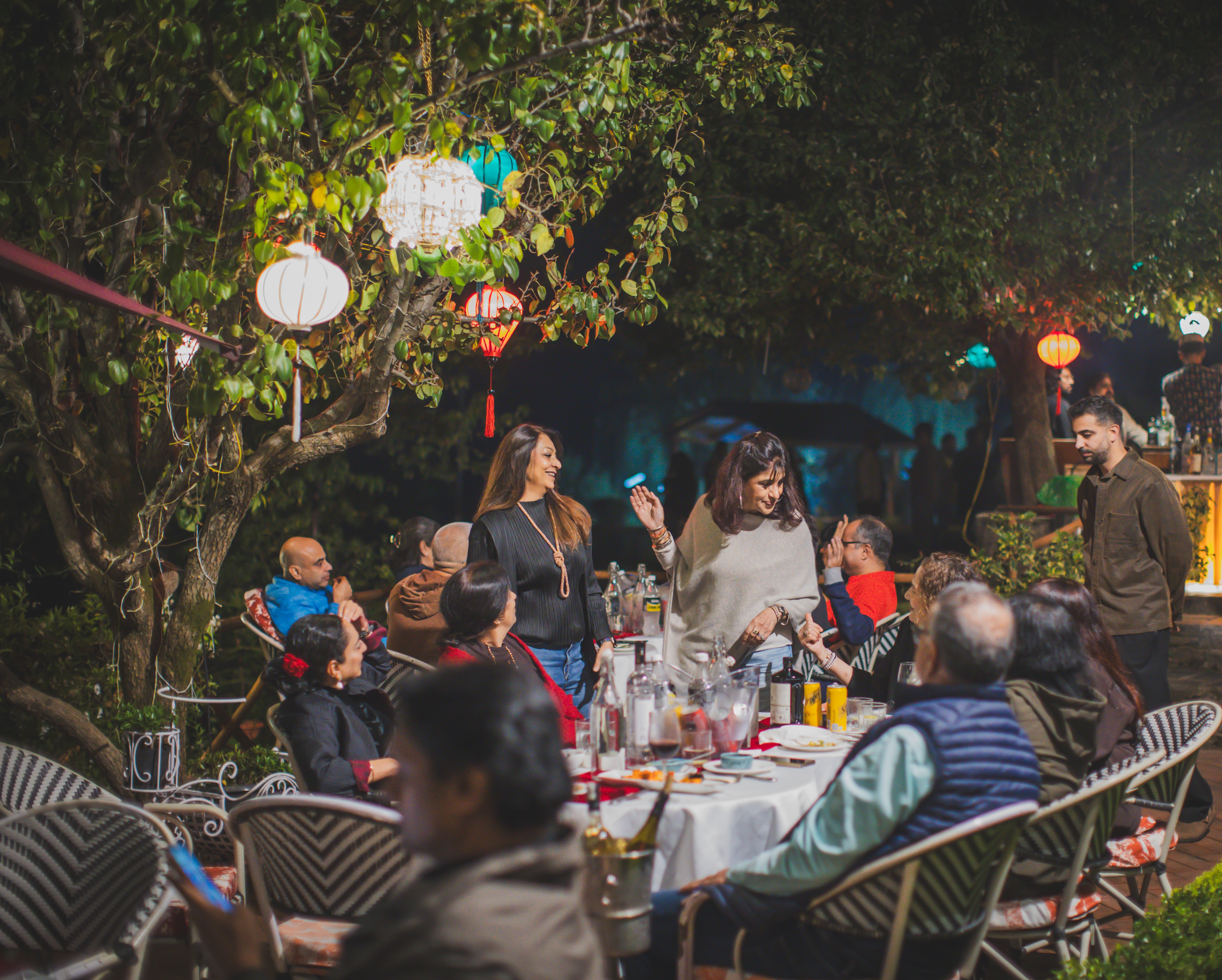 Guests gathered around outdoor dining tables under decorative lanterns at Auramah Festival 2026 in Naldehra.