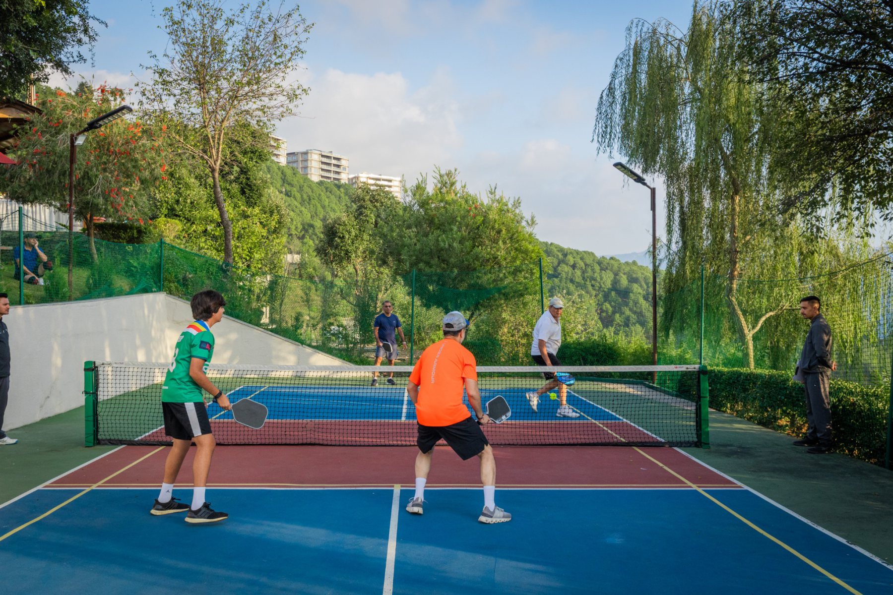 Four players competing in a pickleball match on a blue and red court at Auramah Festival 2026
