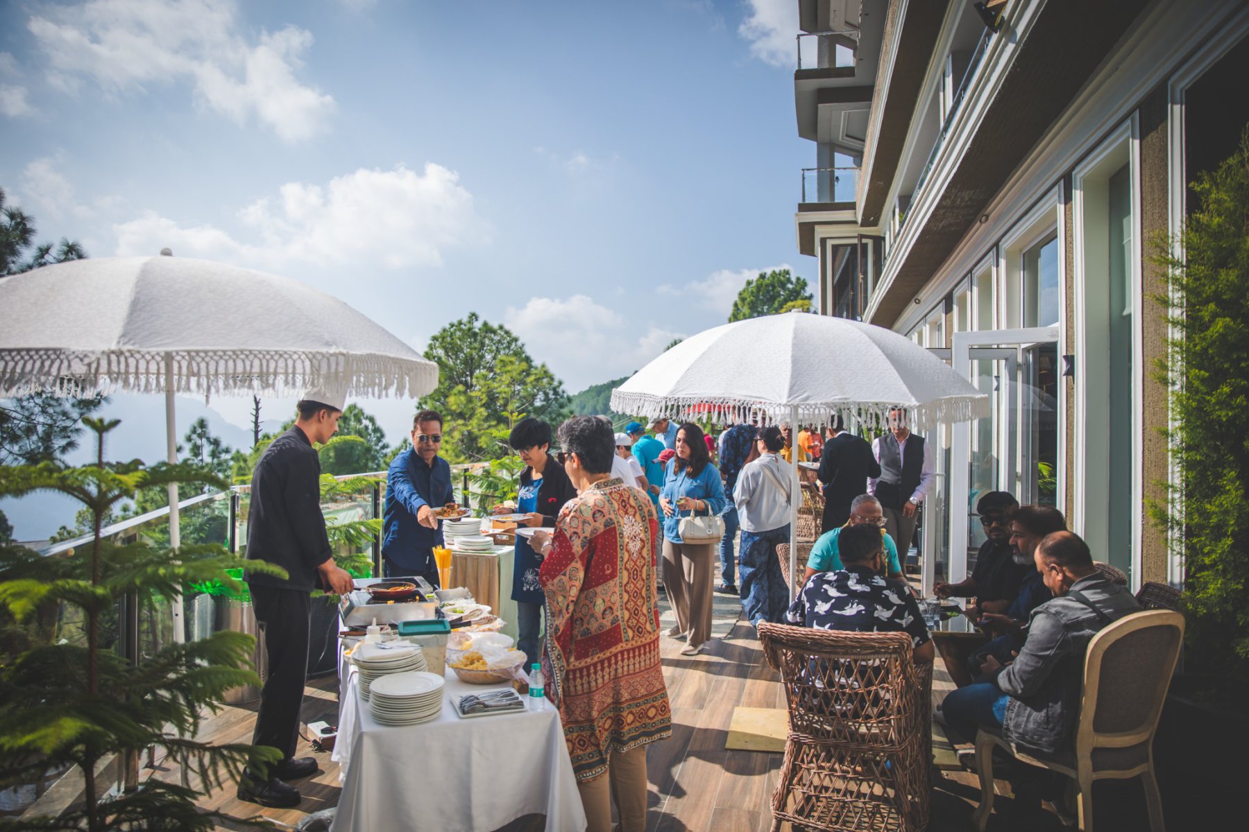 Guests dining on a sunlit terrace at The Manor Clubhouse during Auramah Festival 2026